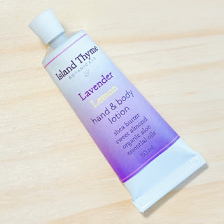 A tube of Lavender Lemon Lotion from Island Thyme Botanicals, enriched with shea butter, sweet almond oil, organic aloe vera, and essential oils, rests on a light wooden surface.