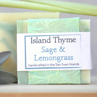 A bar of Sage & Lemongrass Soap, handcrafted in the San Juan Islands with a green and white marbled design, features refreshing lemongrass and essential oils, and is accented by sage leaves.