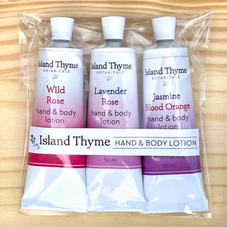 The Floral Travel Lotion Trio includes three 50 ml tubes (Wild Rose, Lavender, Jasmine Blood Orange) of Island Thyme Botanicals lotions in a clear plastic bag with travel-sized moisturizers.