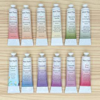 The Travel Lotion Complete Set features 12 travel-size hand & body lotions in scents like Grapefruit Mandarin, Sweet Almond, and Ginger Cardamom—perfect for daily use or gifting. Arranged neatly on a wooden surface.