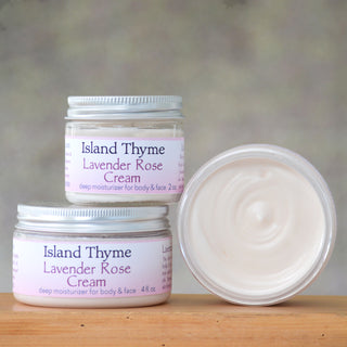 Three jars of Lavender Rose Cream are displayed—two closed jars stacked on the left, and one open jar on the right reveals the creamy, light pink formula inside, perfect for dry and sensitive skin.