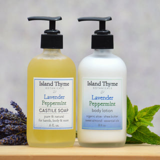 The Lavender Peppermint Lotion + Soap Set stands side by side with lavender sprigs and mint leaves in the background, creating a refreshing display. Eco Jars complete the scene.