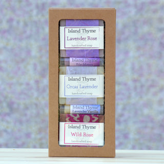 The Floral Gift Box features five handcrafted Island Thyme soap bars—Lavender Rose, Blackberry, Orcas Lavender, Lavender Vanilla, and Wild Rose—in a cardboard box set against a softly blurred floral background.
